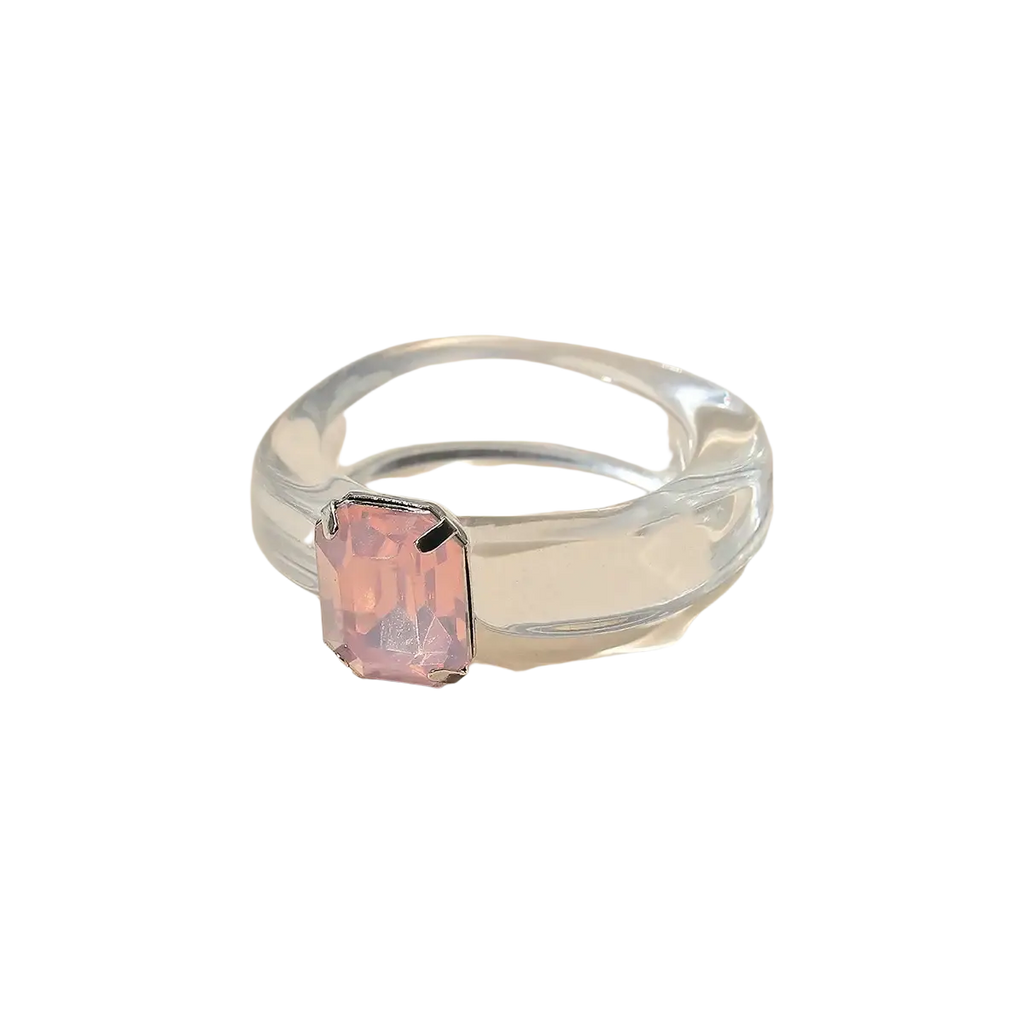 A colorful resin crystal geometric ring for women with a translucent clear band and a rectangular pink gemstone center