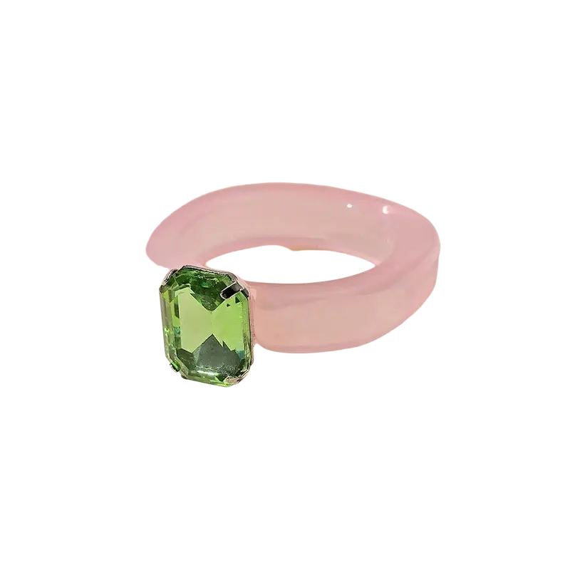 Colorful resin crystal geometric ring for women with a translucent pink band and emerald-cut green gemstone set in silver metal