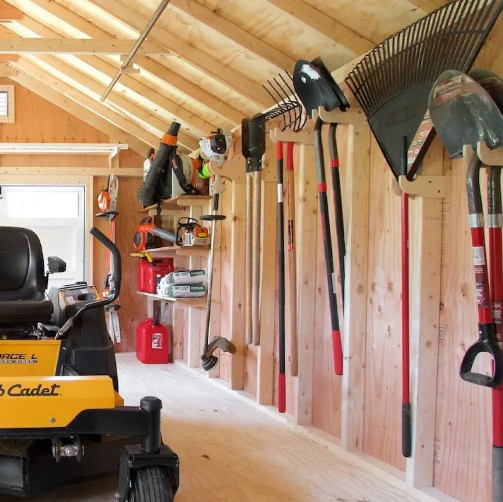 Stud mounted garden tool wall organizer kit with red and black handled shovels and rakes hung on wooden rack