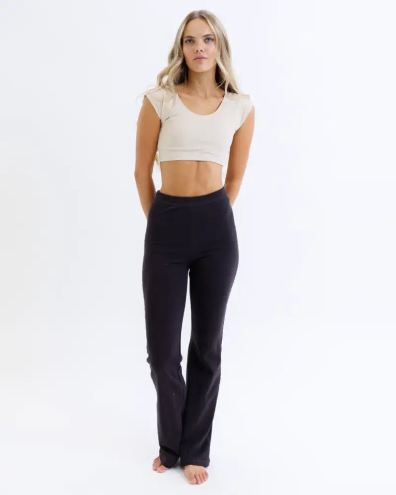 Black high-waisted flared yoga pants made of moisture-wicking fabric shown from the back for active wear comfort