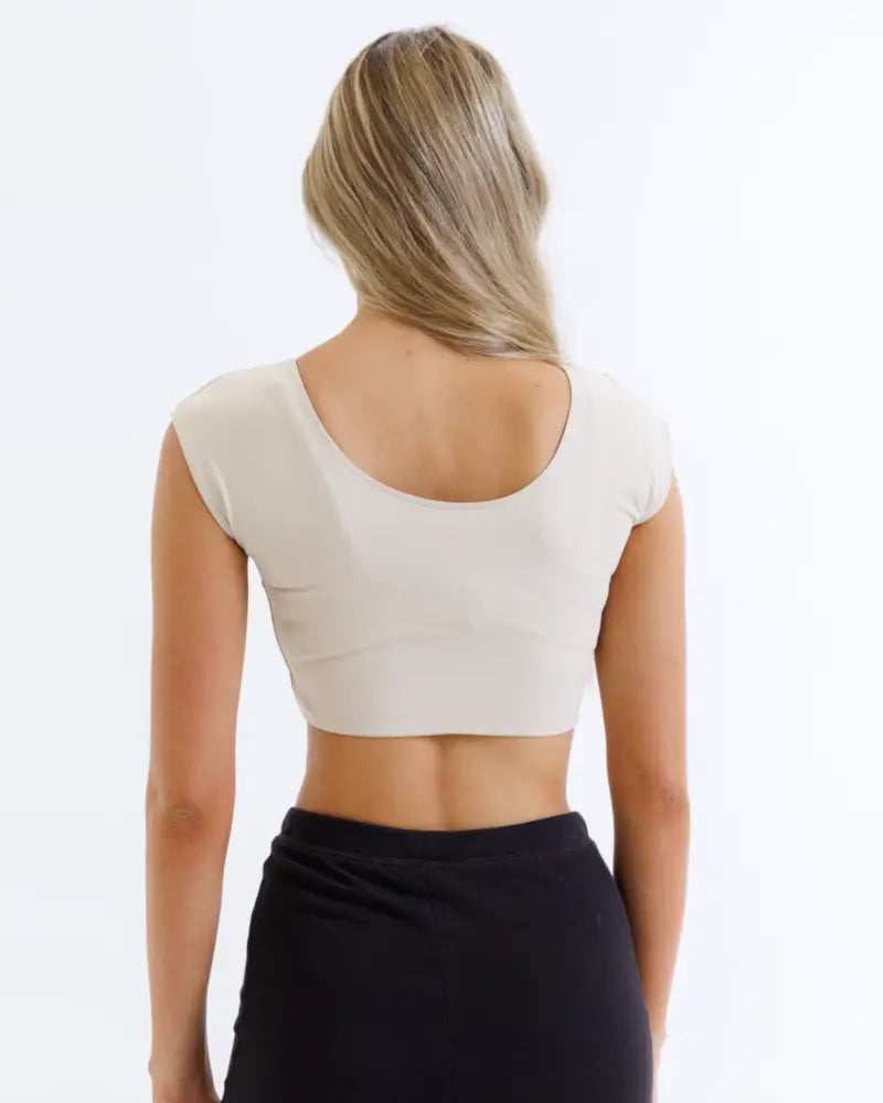Beige contour demi cropped shaping tee with moisture wicking fabric shown from the back with rounded neckline