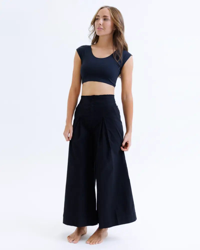 Black high-waisted wide-leg pants with flowing pleated design paired with contour demi cropped shaping tee with moisture wicking fabric