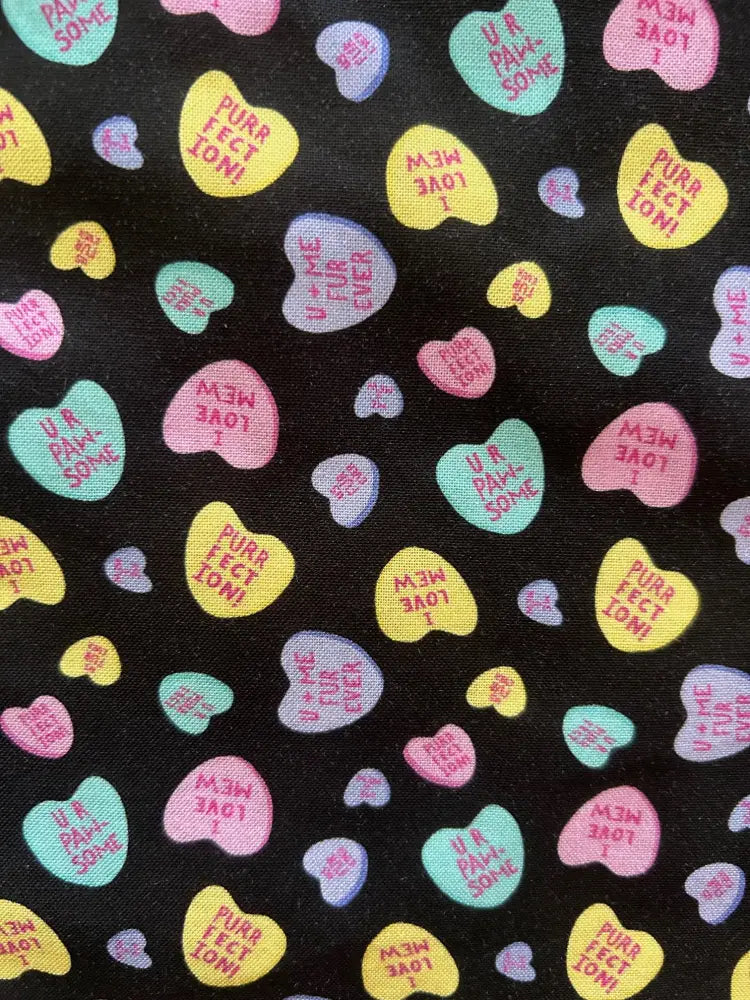 Black fabric vintage conversation hearts bow neck blouse with colorful heart candy patterns and playful phrases
