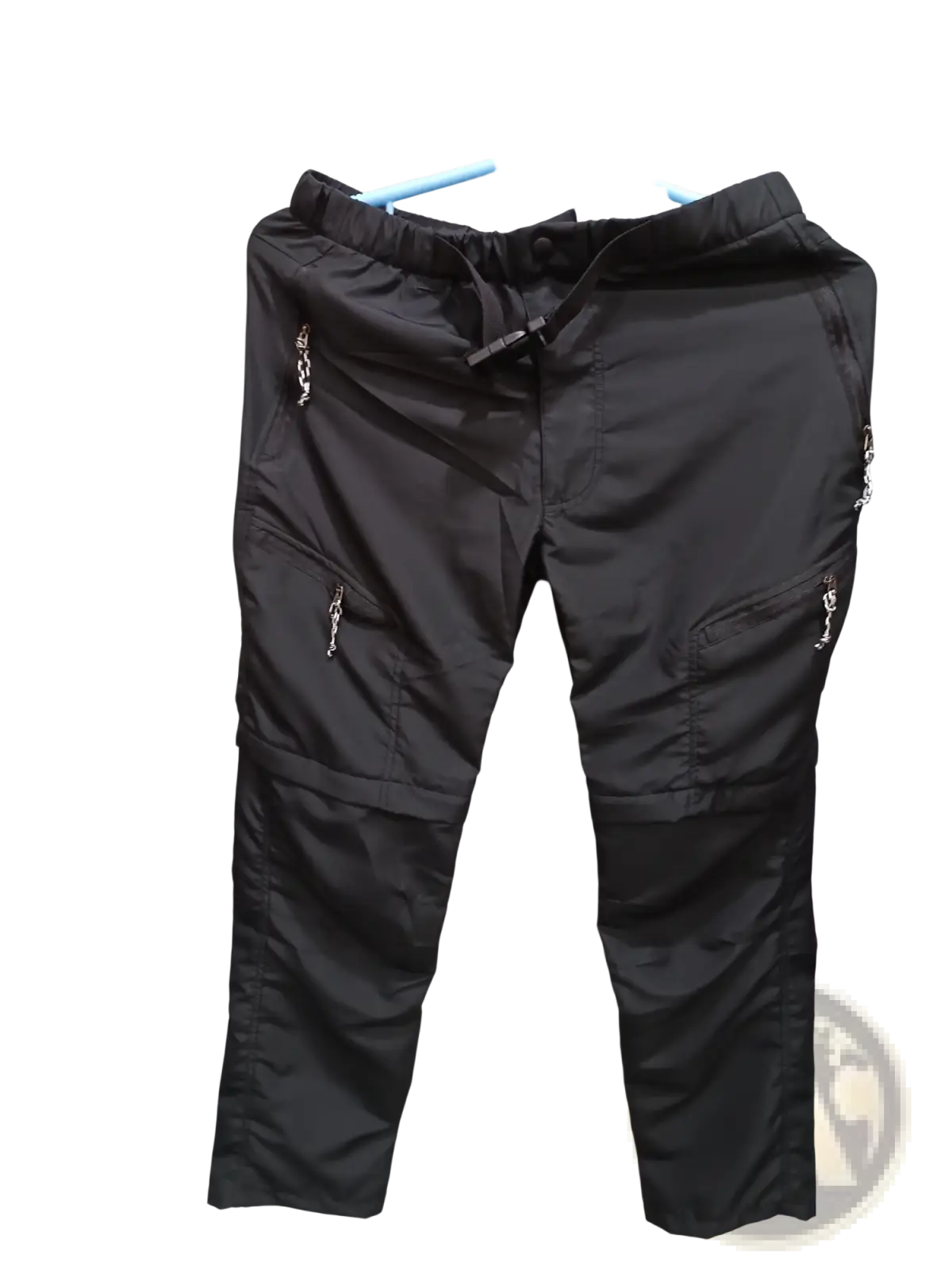 Convertible tactical hiking pants in black cargo style with elastic waistband drawstring multiple zippered pockets and silver hardware