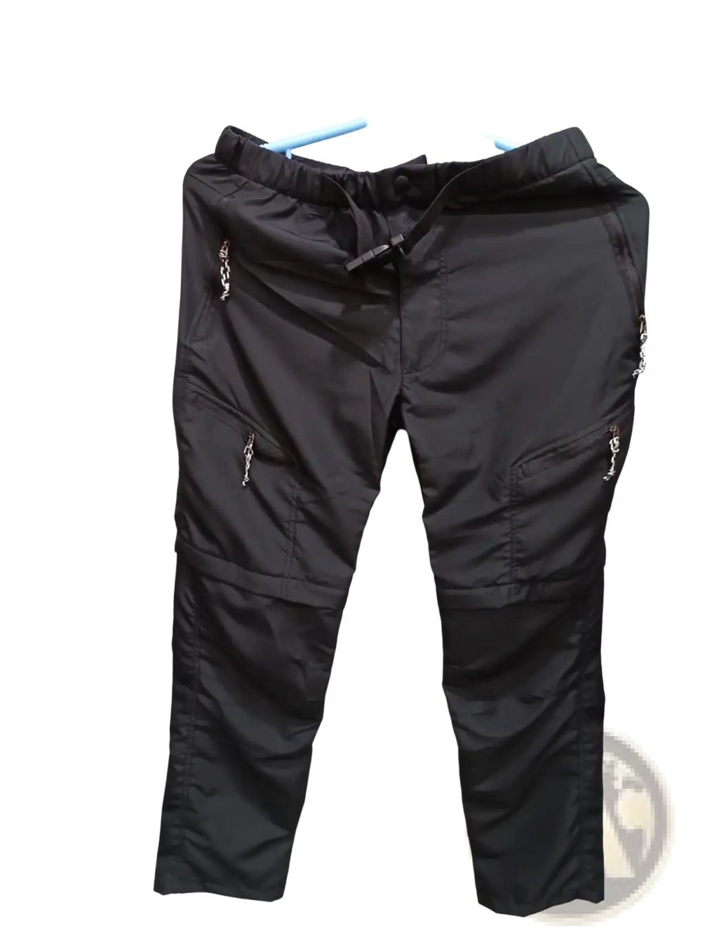 Convertible tactical hiking pants in black cargo style with elastic waistband drawstring multiple zippered pockets and silver hardware