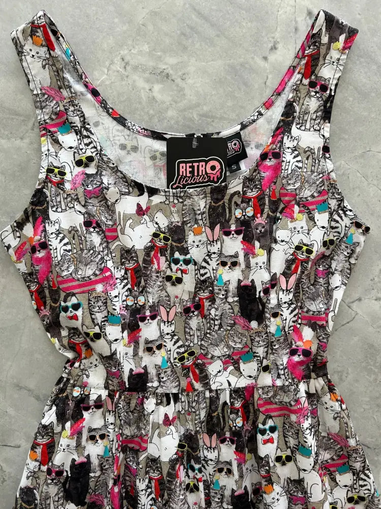 A sleeveless fit and flare dress with a vibrant cartoon cat print on white called cool cats retro shorter length