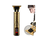 Gold-colored cordless electric hair clipper with intricate eiffel tower engraving and digital display for professional barber use