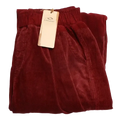 A pair of burgundy corduroy wide leg pants with elastic waist, soft textured fabric, and neatly folded hems