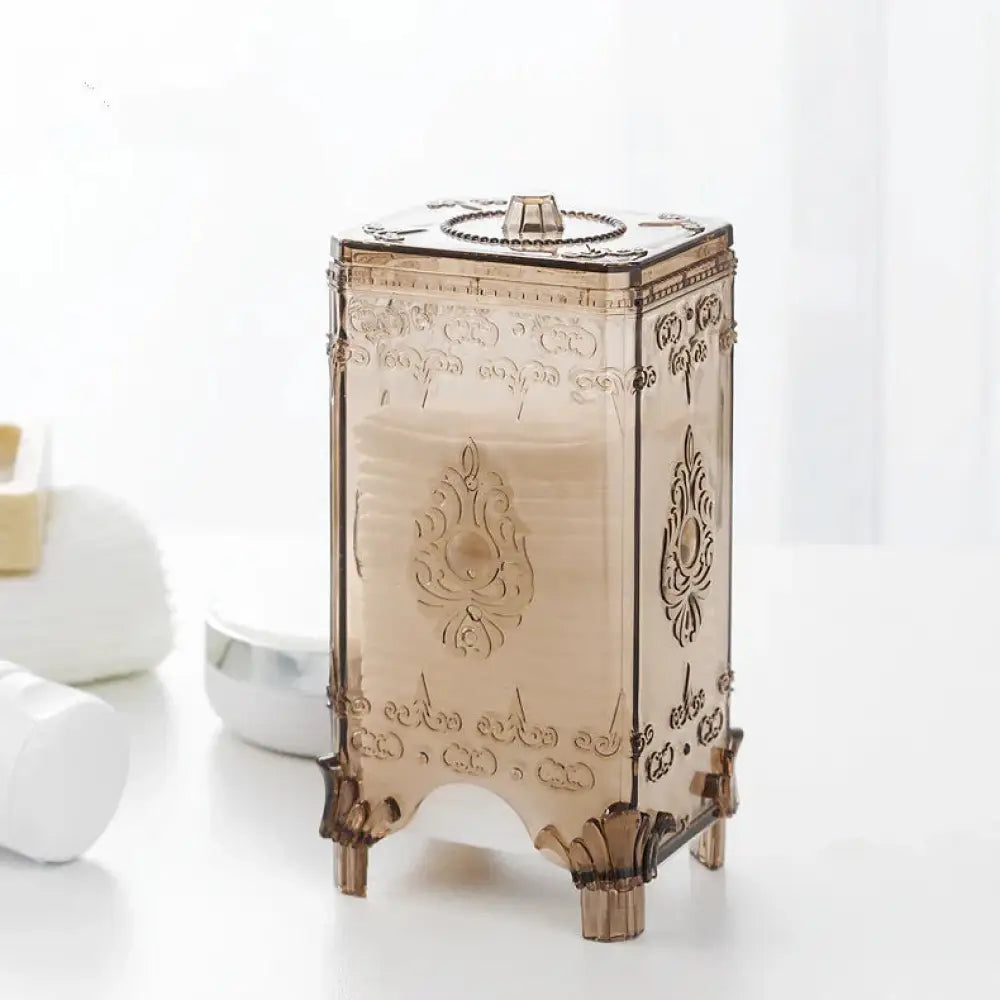 Ornate embossed amber glass cosmetic storage box with intricate gold-toned floral and scrollwork patterns