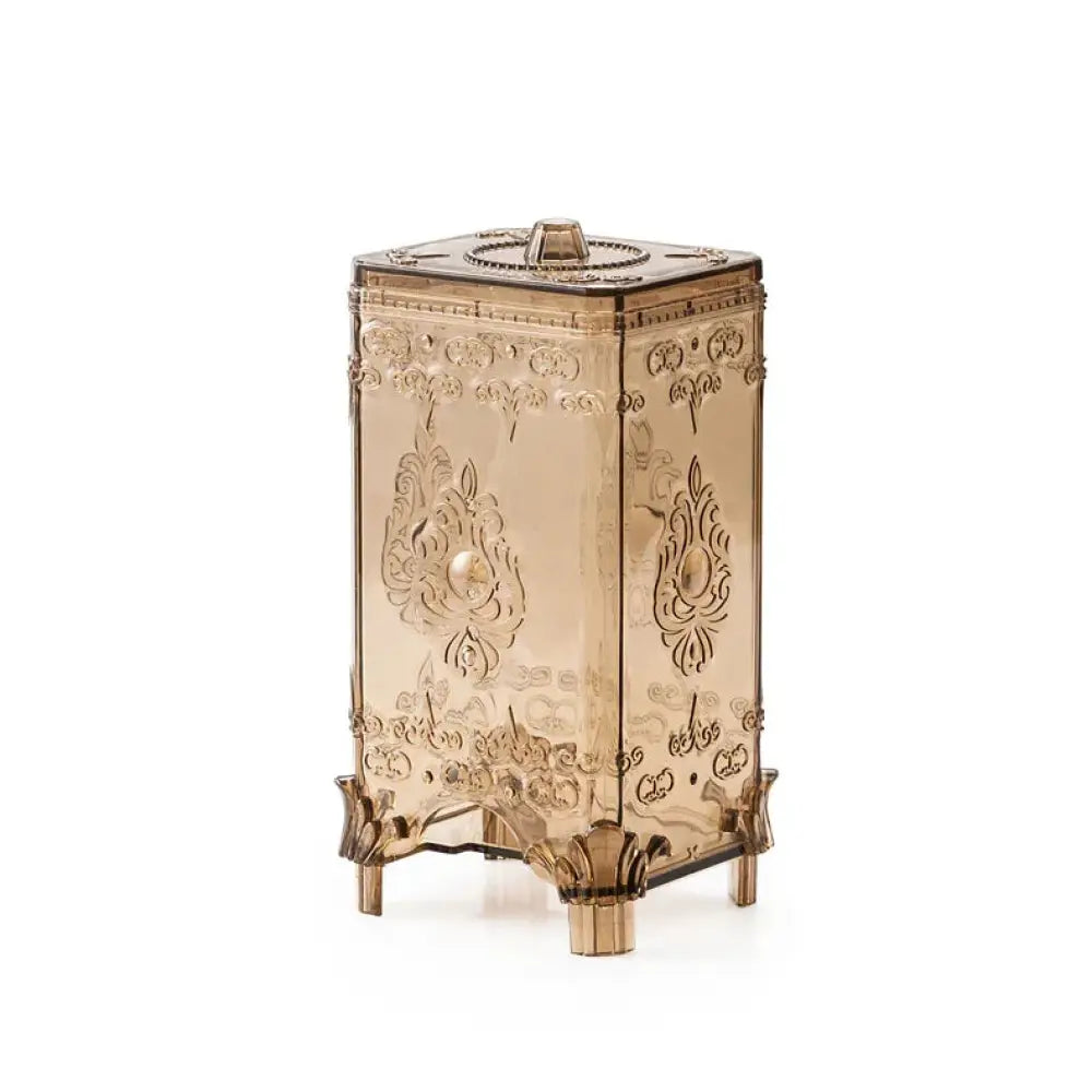Ornate embossed amber glass cosmetic storage box with hinged lid gold floral scrollwork and decorative feet