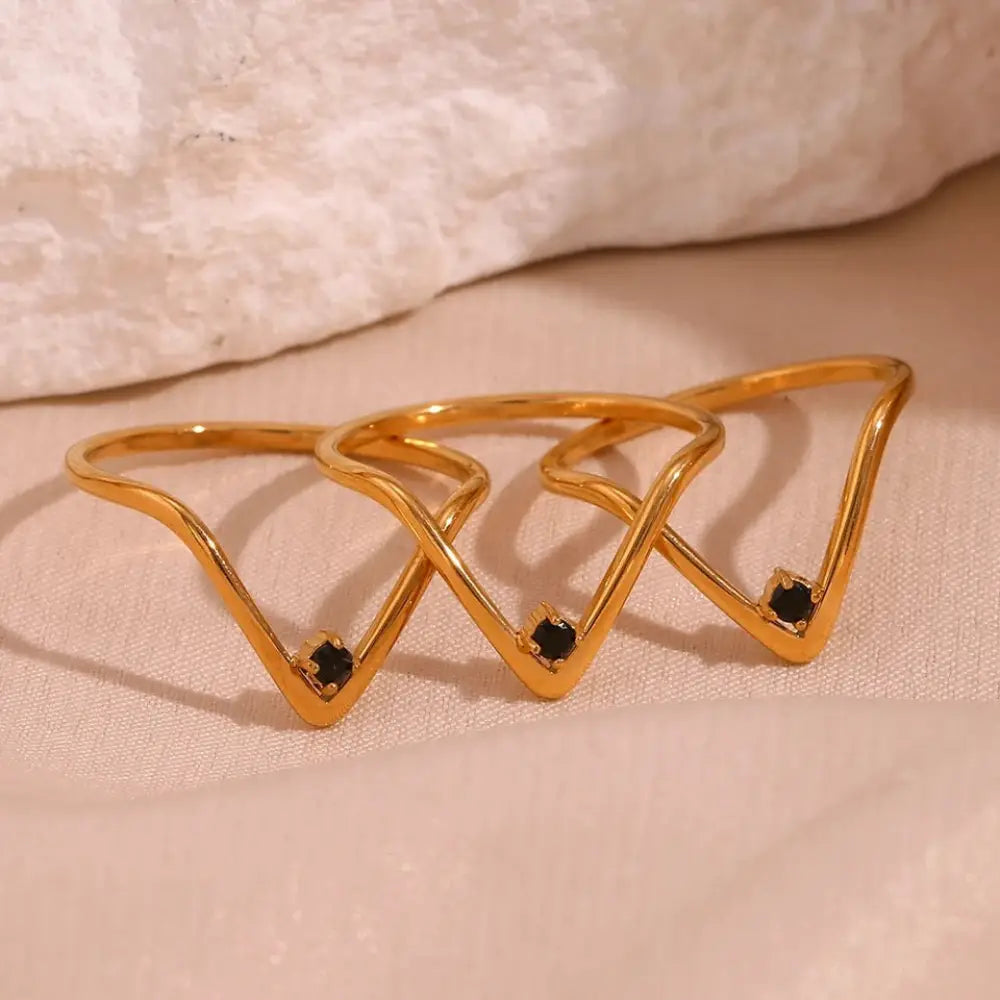 Gold-toned geometric cosmo gold v shape ring set with black gemstone accents designed for waterproof wear