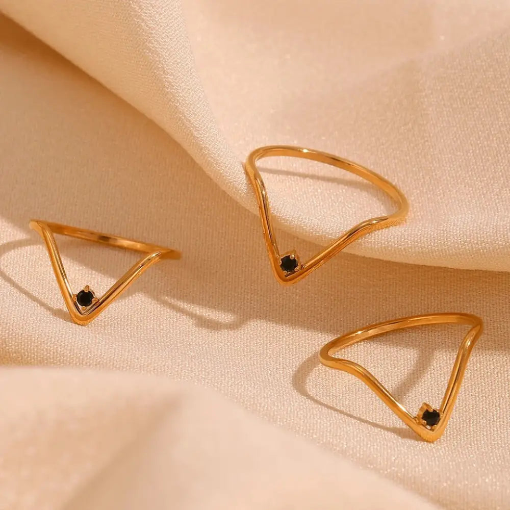 Cosmo gold v shape waterproof ring featuring gold-toned geometric design with black stone accents