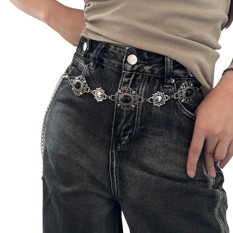 Silver ornate cosplay waist chain belt with black oval stones and intricate metalwork worn over dark denim jeans