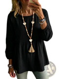 A long boho-style necklace with wooden beads white heart-shaped pendants and tassel paired with cotton doll shirt loose fit top
