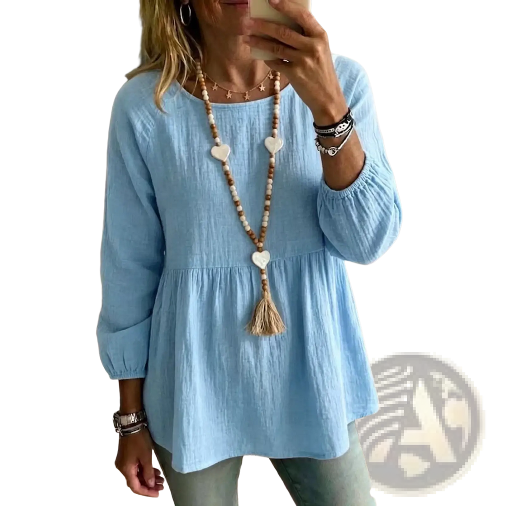Light blue cotton doll shirt with long sleeves, loose fit, gathered waist, and elastic cuffs for casual wear