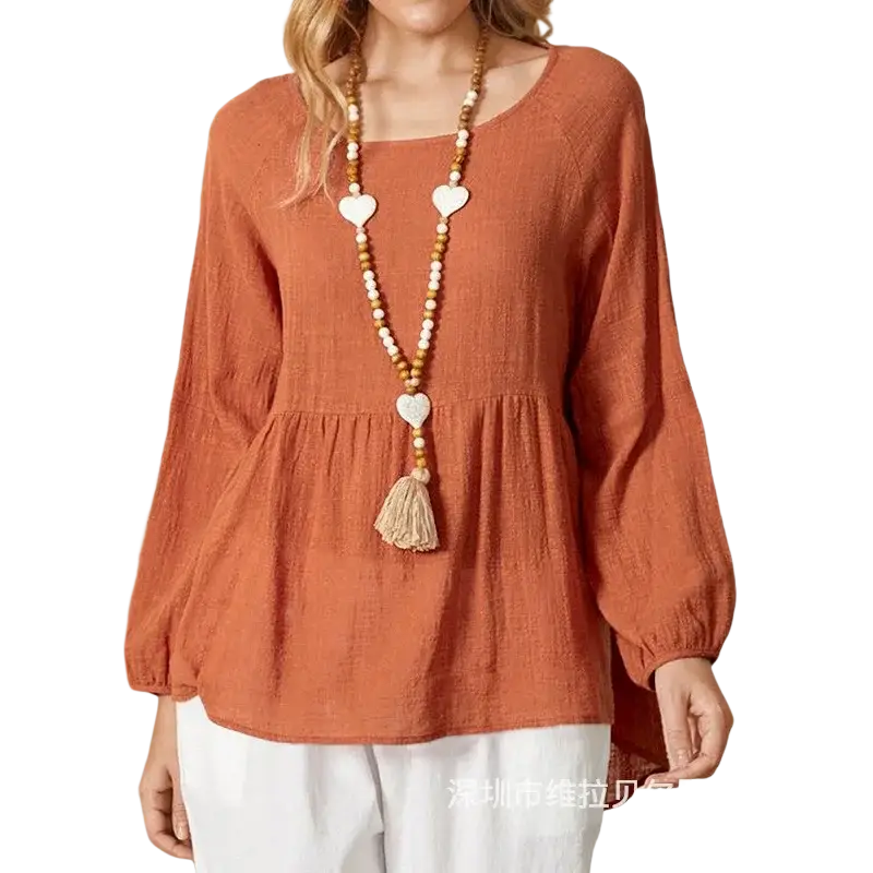 A soft rust-colored cotton linen long sleeve loose blouse with a relaxed fit and gathered waist