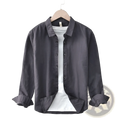 Dark gray cotton linen men long sleeve button up shirt with rolled cuffs and subtle texture on wooden hanger