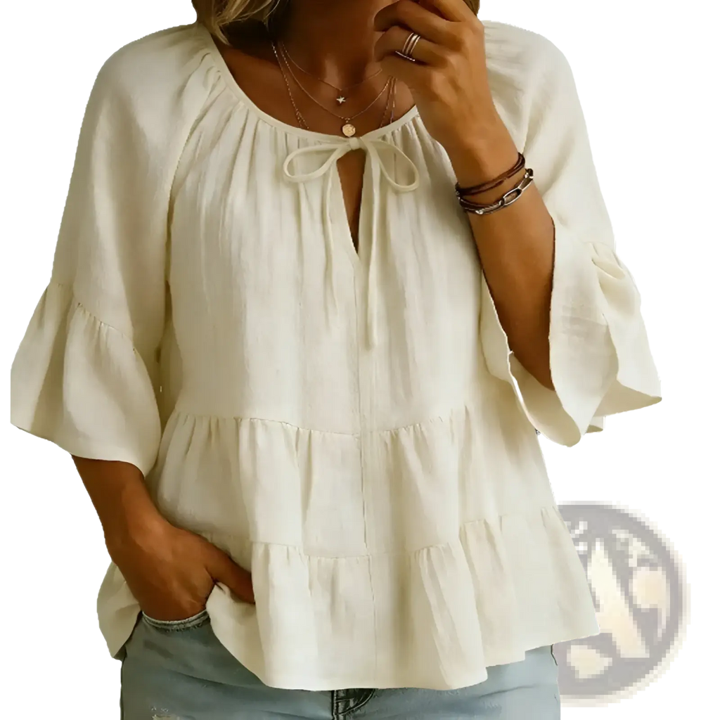 Cream-colored cotton linen blouse top with lightweight fabric, tie-front neckline, and ruffled three-quarter sleeves