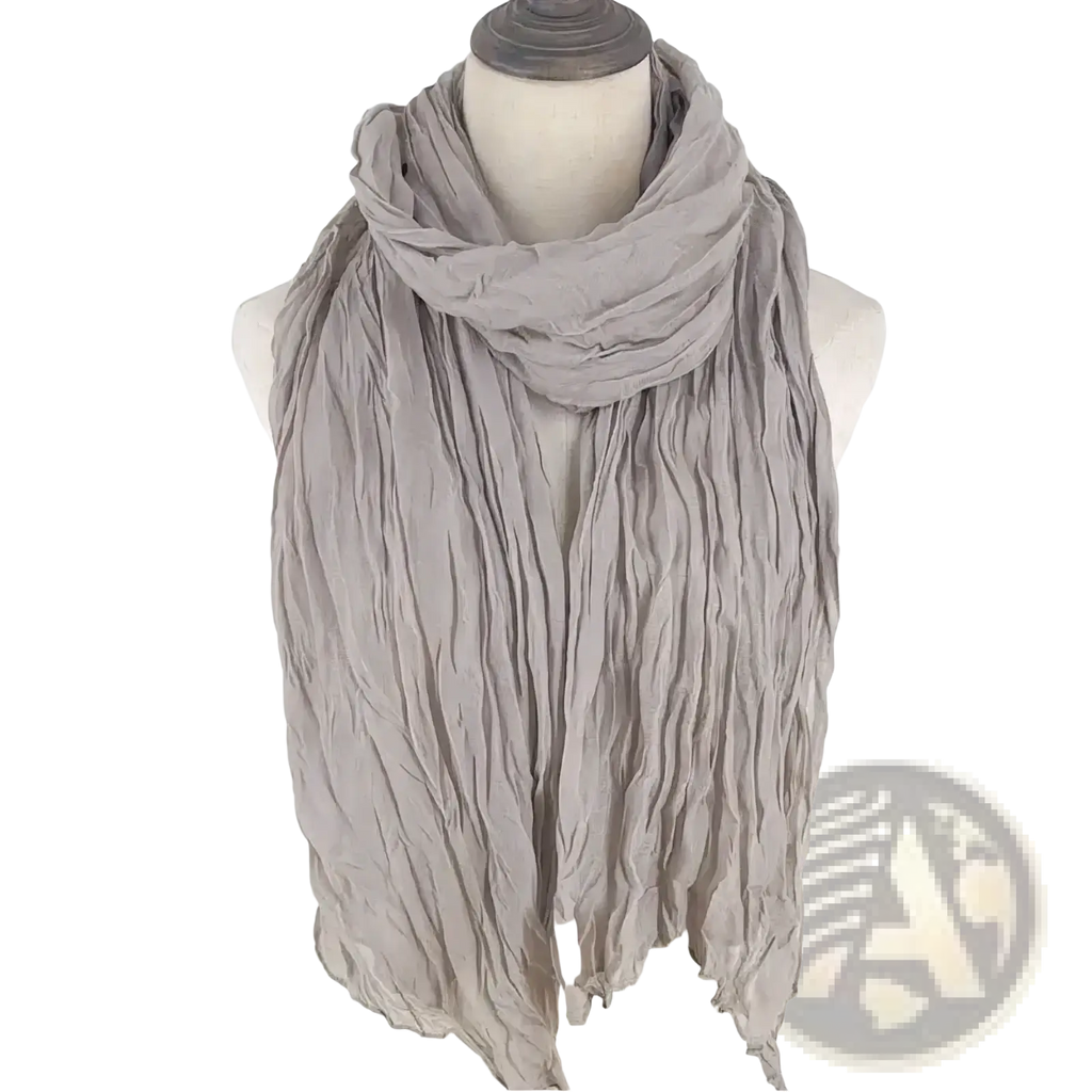 A soft light gray cotton linen scarf with crinkled texture draped elegantly as a solid color shawl for women