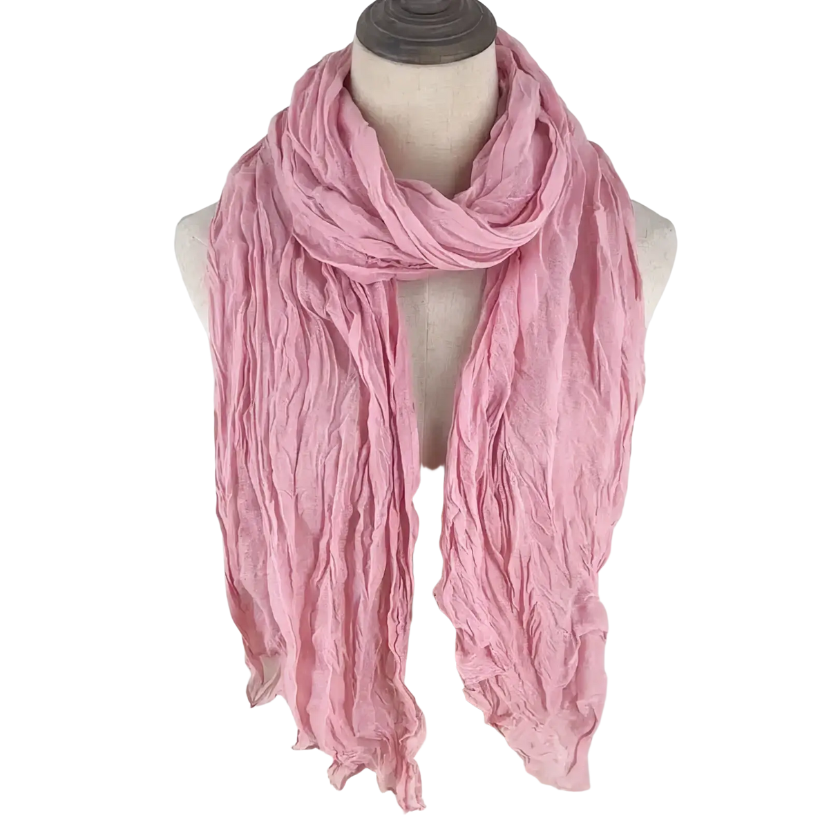 A soft dusty pink cotton linen scarf for women draped elegantly around a mannequin’s neck showcasing its crinkled texture