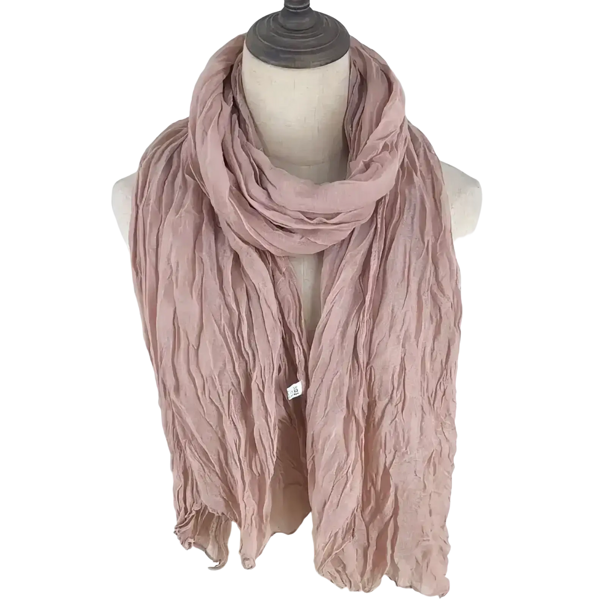 A soft dusty rose cotton linen scarf with a crinkled texture elegantly draped on a mannequin for women