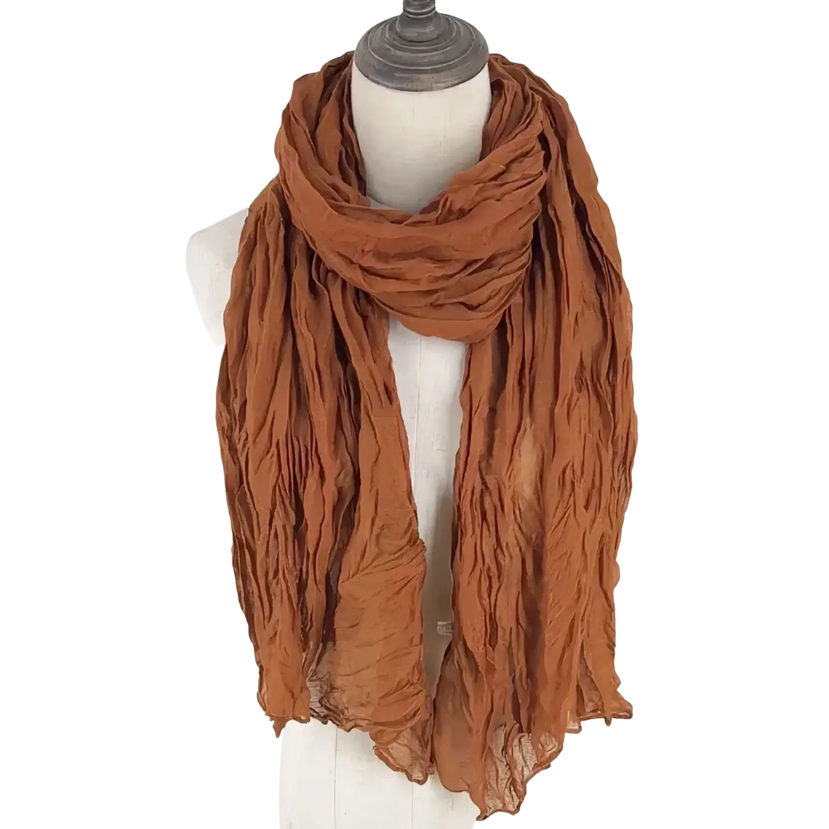 A rust-colored cotton linen scarf for women with crinkled texture and lightweight flowing fabric draped on a mannequin