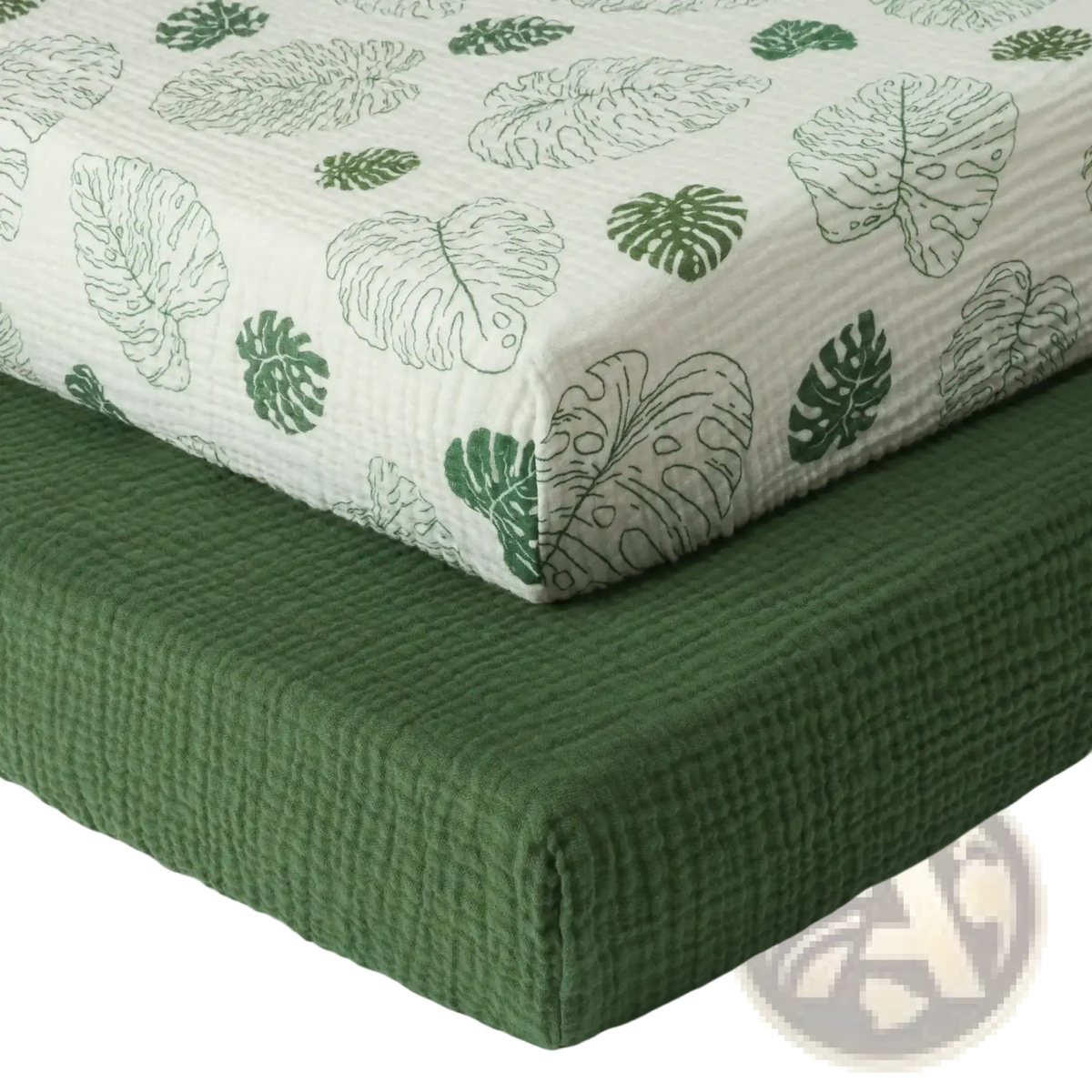 White quilted cotton muslin crib sheet with green monstera leaf patterns for infant bedding use