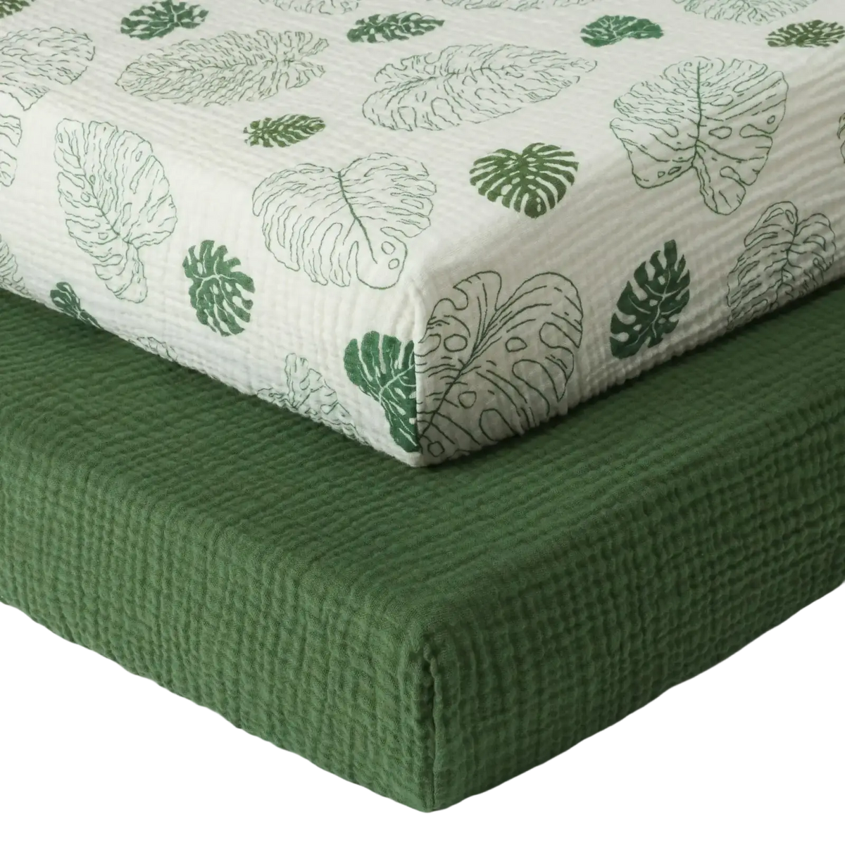 White quilted cotton muslin crib sheet with green monstera leaf patterns for infant bedding use