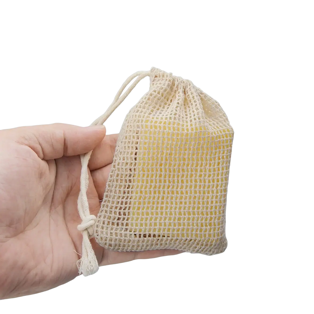Beige cotton soap saver bag with drawstring holding a yellow bar of soap in a 3 pack cotton soap set