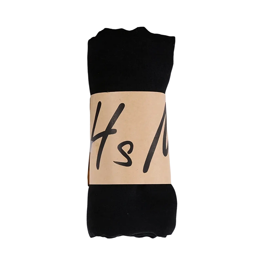 Black cotton winter scarf for women rolled neatly with beige paper band featuring handwritten-style lettering