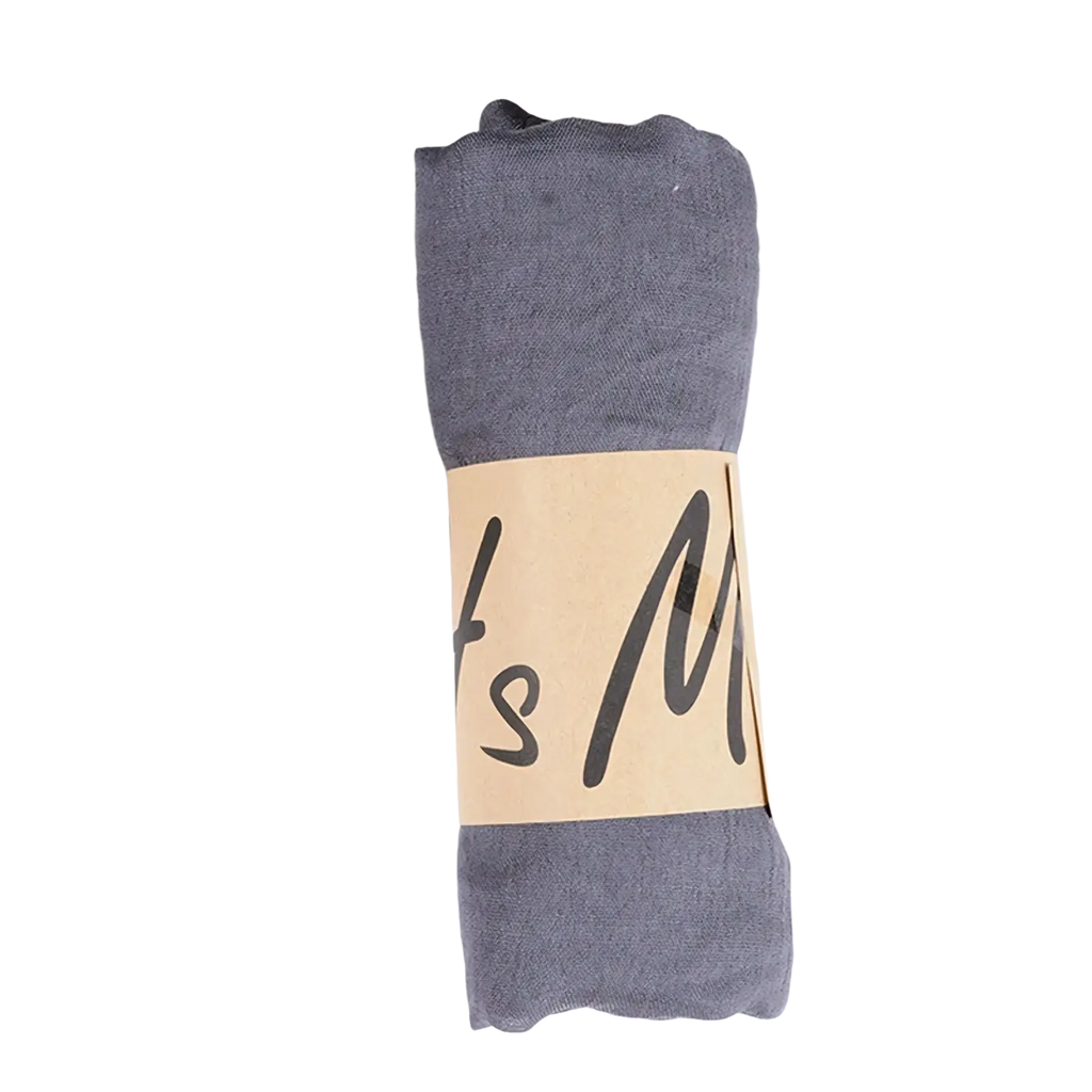 A neatly rolled gray cotton winter scarf for women with a beige paper band featuring black cursive lettering