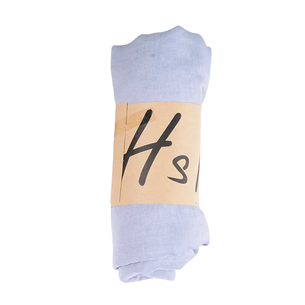 A neatly rolled pair of light blue sheer cotton winter tights with a beige paper band featuring black lettering