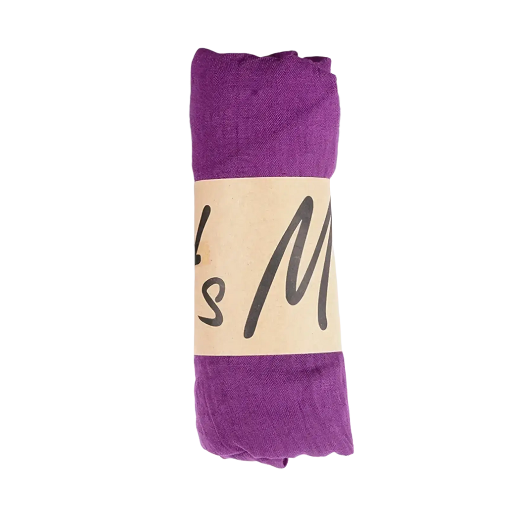 A rolled-up purple cotton winter scarf with a beige label featuring black cursive text for women