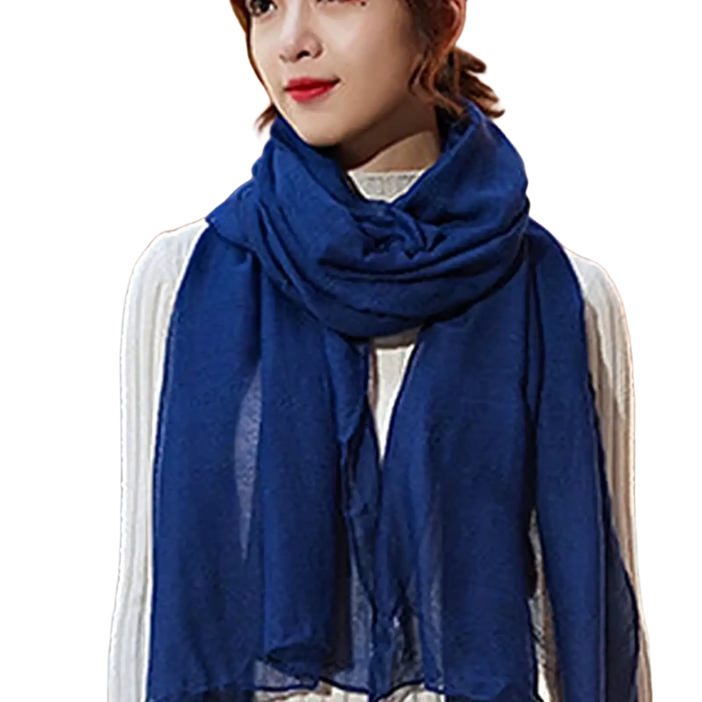 A soft deep blue cotton winter scarf for women made of lightweight slightly sheer fabric draped elegantly