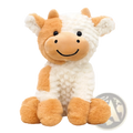 A plush cow toy with a fluffy white and tan coat smiling while sitting as a soft stuffed animal