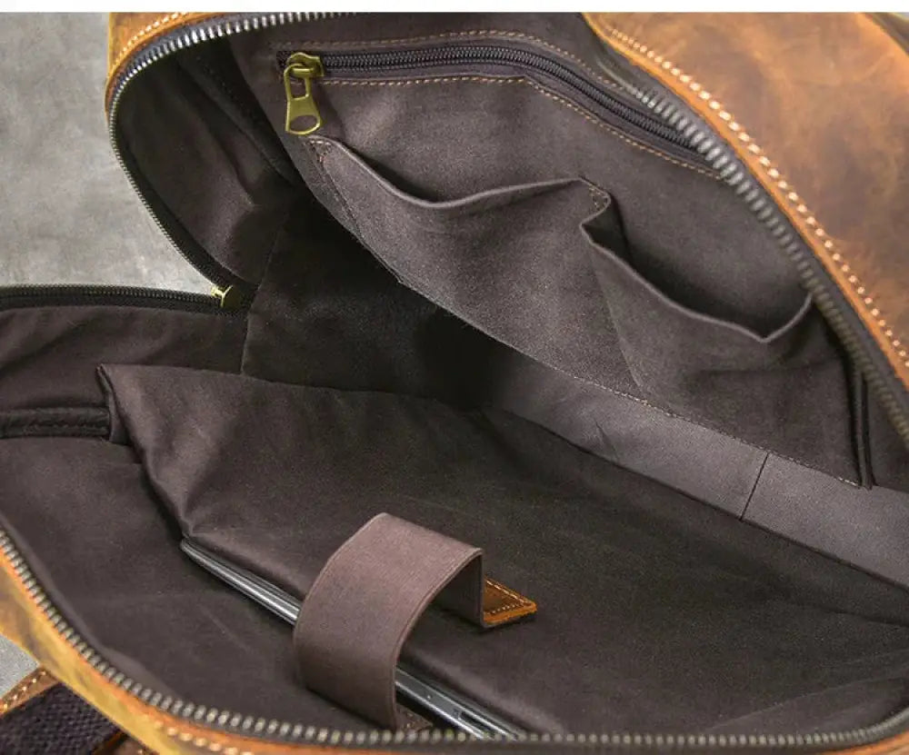 Vintage crazy horse leather adventure backpack in brown with dark gray interior lining and olive green zipper pulls