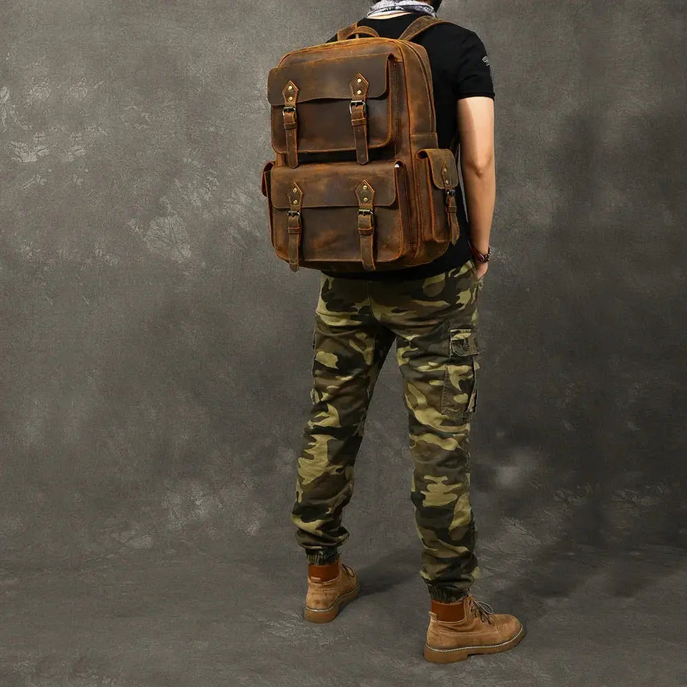 Brown leather vintage crazy horse adventure backpack with multiple flap pockets and brass hardware for outdoor use