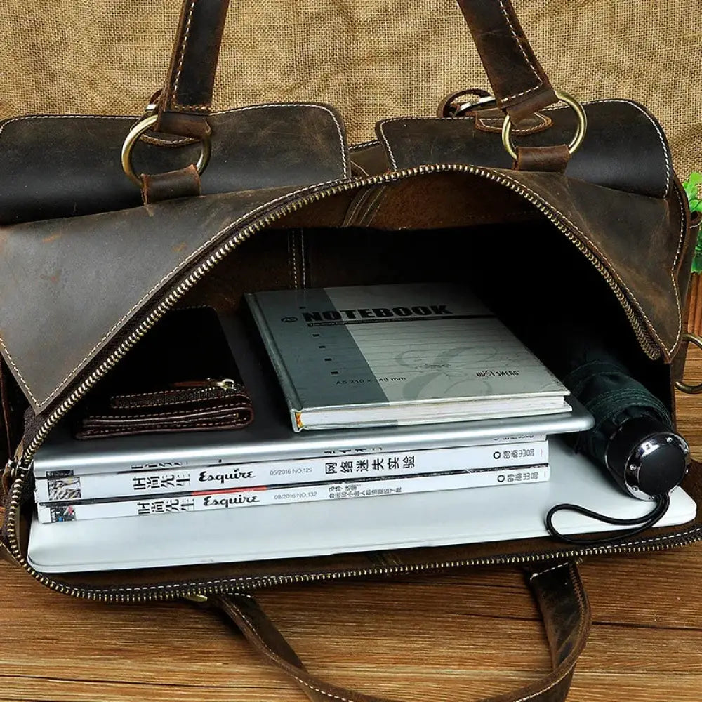 Vintage crazy horse leather satchel bag in brown with brass hardware open to show organized notebooks and essentials