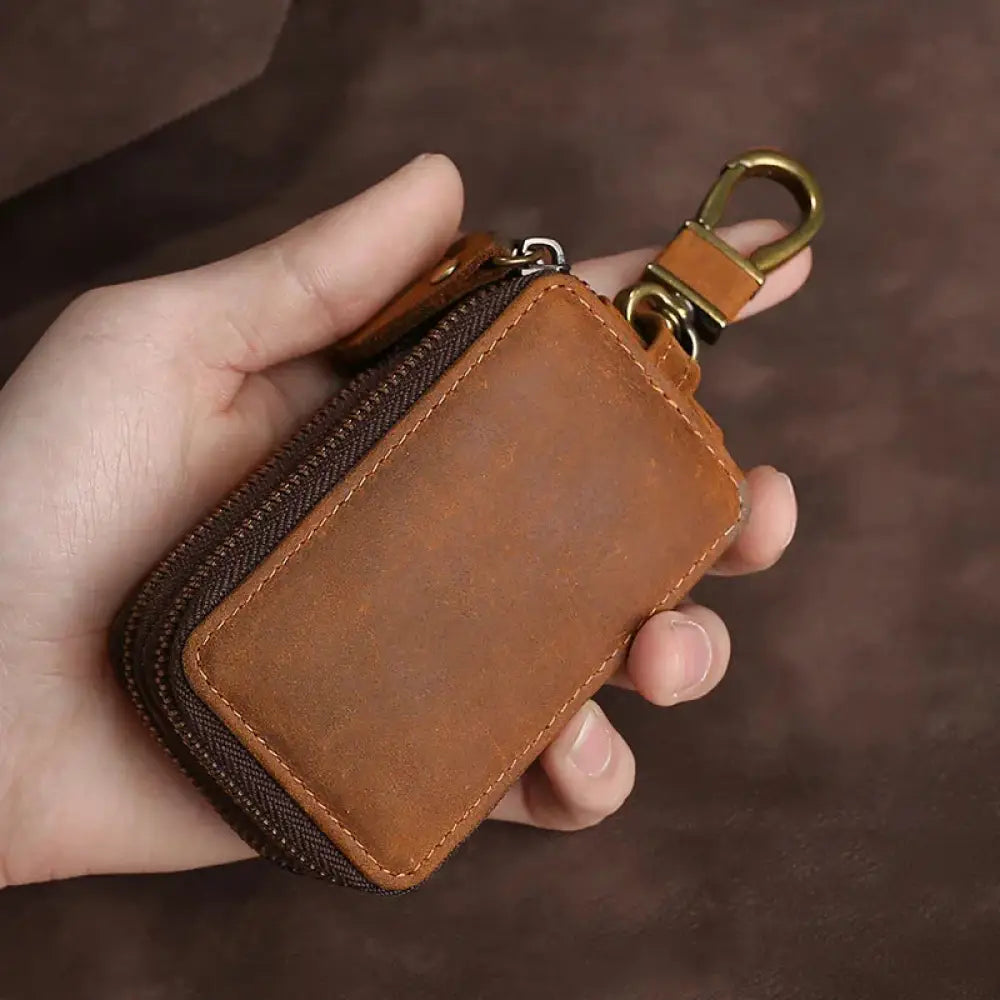 Premium crazy horse leather brown key case with zipper closure and brass-colored metal clasp for secure storage
