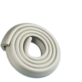Cream foam table corner protector guard with coiled beige foam bumper and soft rounded profile with textured surface