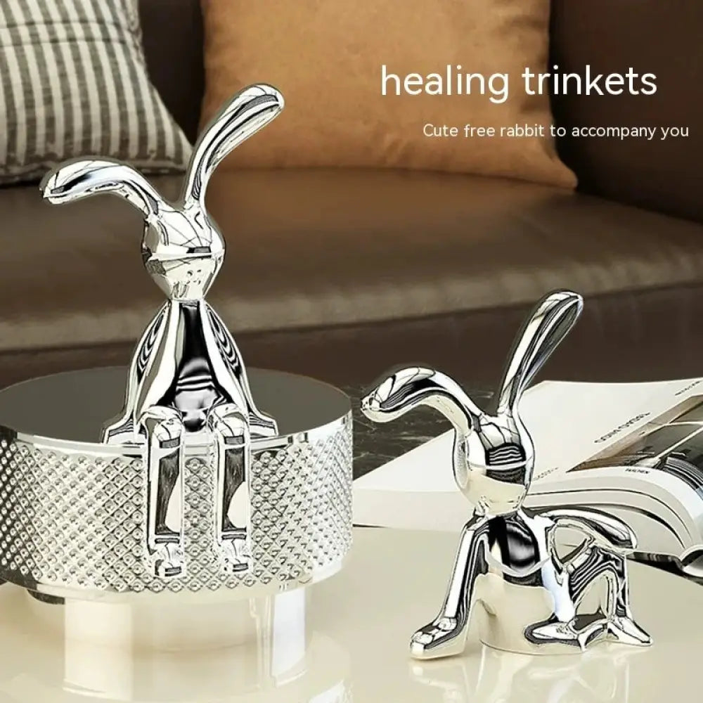 Shiny silver metallic rabbit figurines with reflective surfaces and textured diamond-patterned bases for minimalist decor