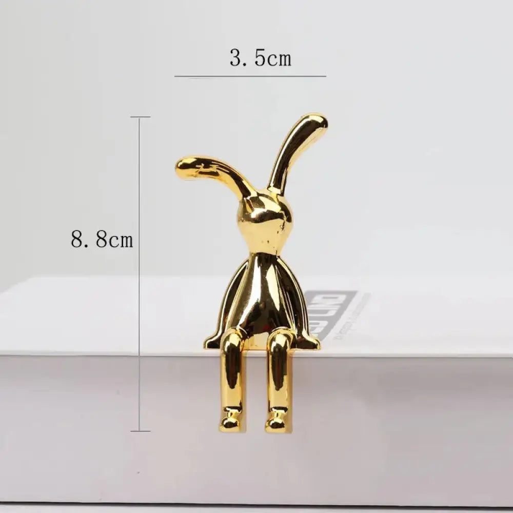 A sleek golden minimalist long eared rabbit figurine with glossy finish for elegant decor display