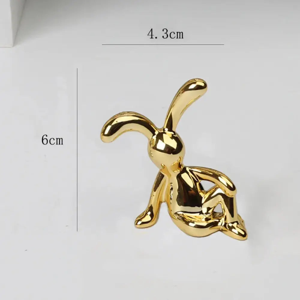 A minimalist golden rabbit figurine decor with a sleek glossy finish and stylized elongated ears