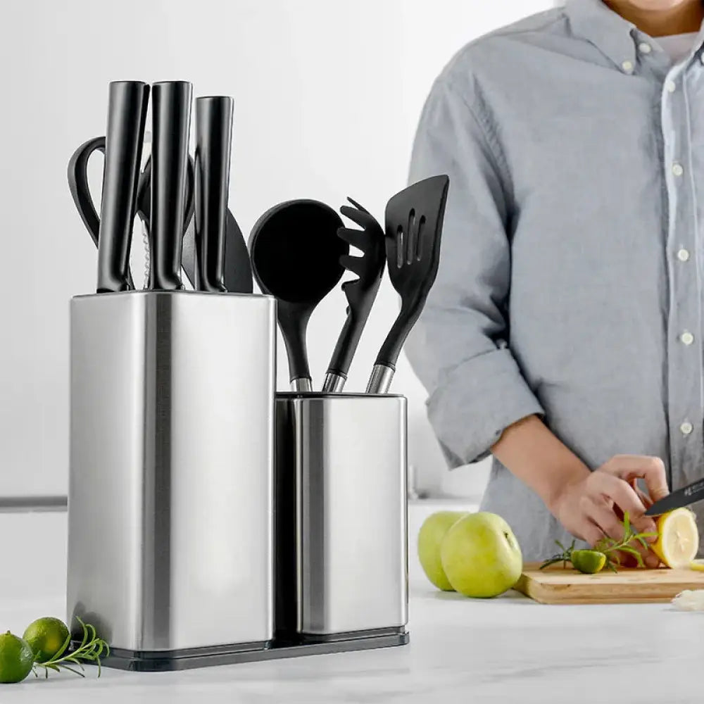 Modern stainless steel universal knife and utensil holder with black handles neatly organizing spatulas knives and spoons