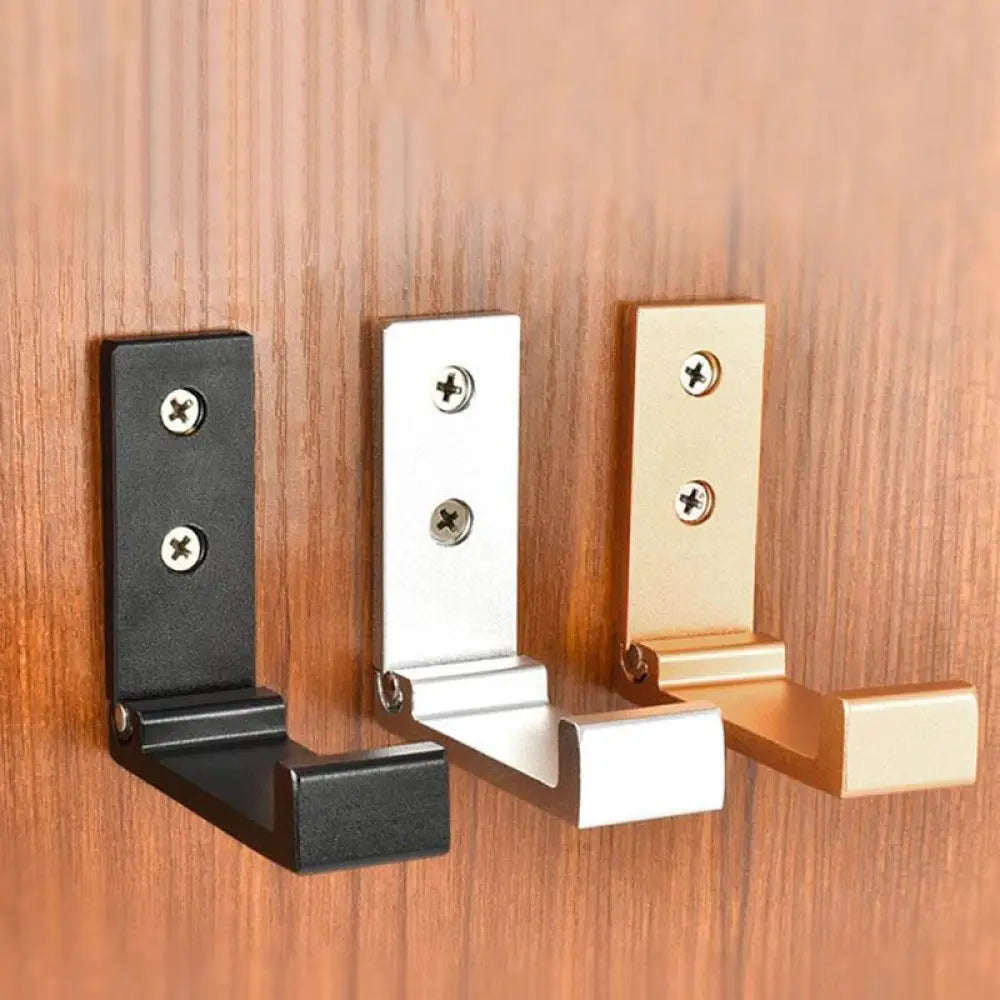 Three foldable aluminum alloy minimalist wall hooks in black silver and gold finishes mounted on wall