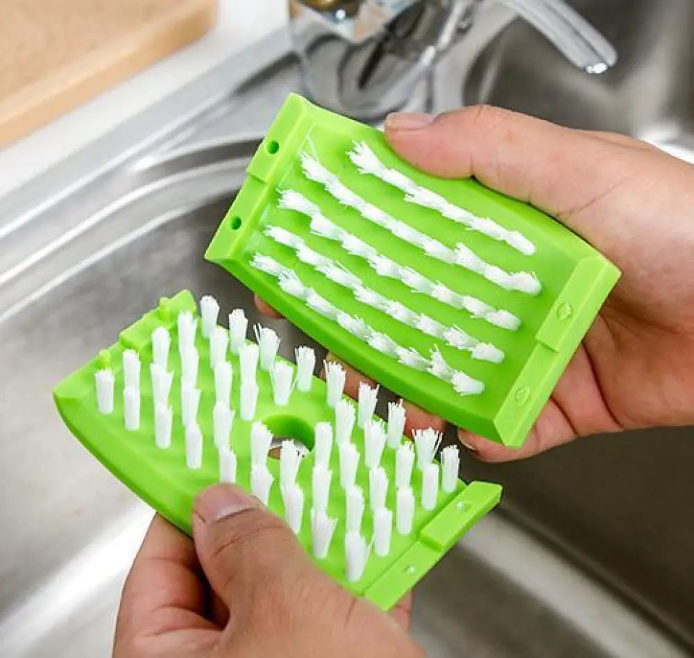 Bright green plastic multiuse suction cup kitchen brush with white bristles and dual scrubbing surfaces for utensils