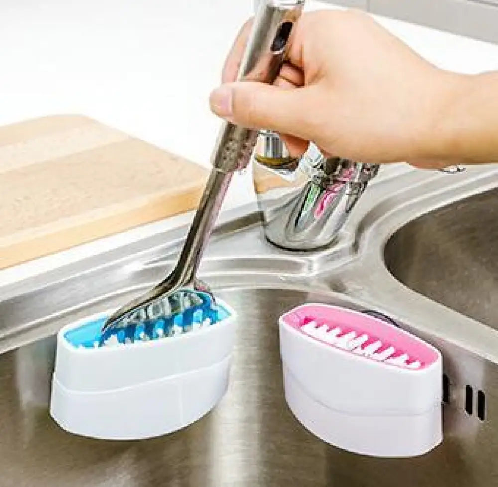 A sleek white plastic multiuse suction cup kitchen brush and utensil scrubber holder with blue and pink interior