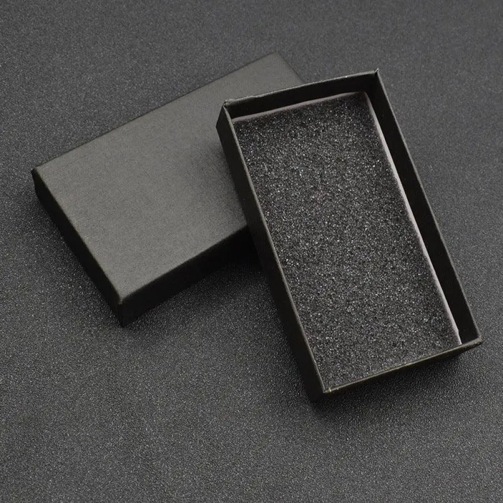 Black rectangular gift box with matte finish and textured foam interior for premium leather and metal carabiner keychain