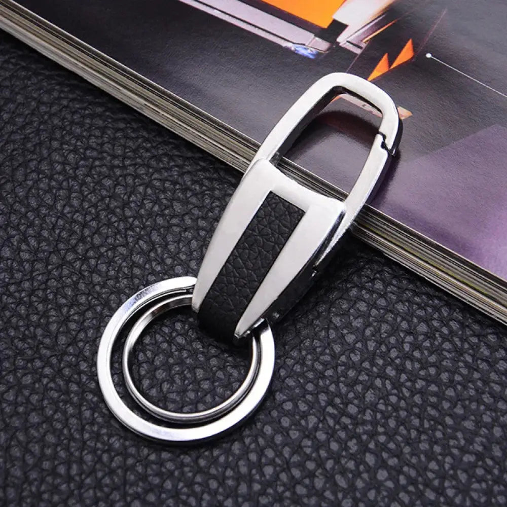 Premium leather and metal carabiner car keychain in silver and black with textured leather strip and sleek metallic finish