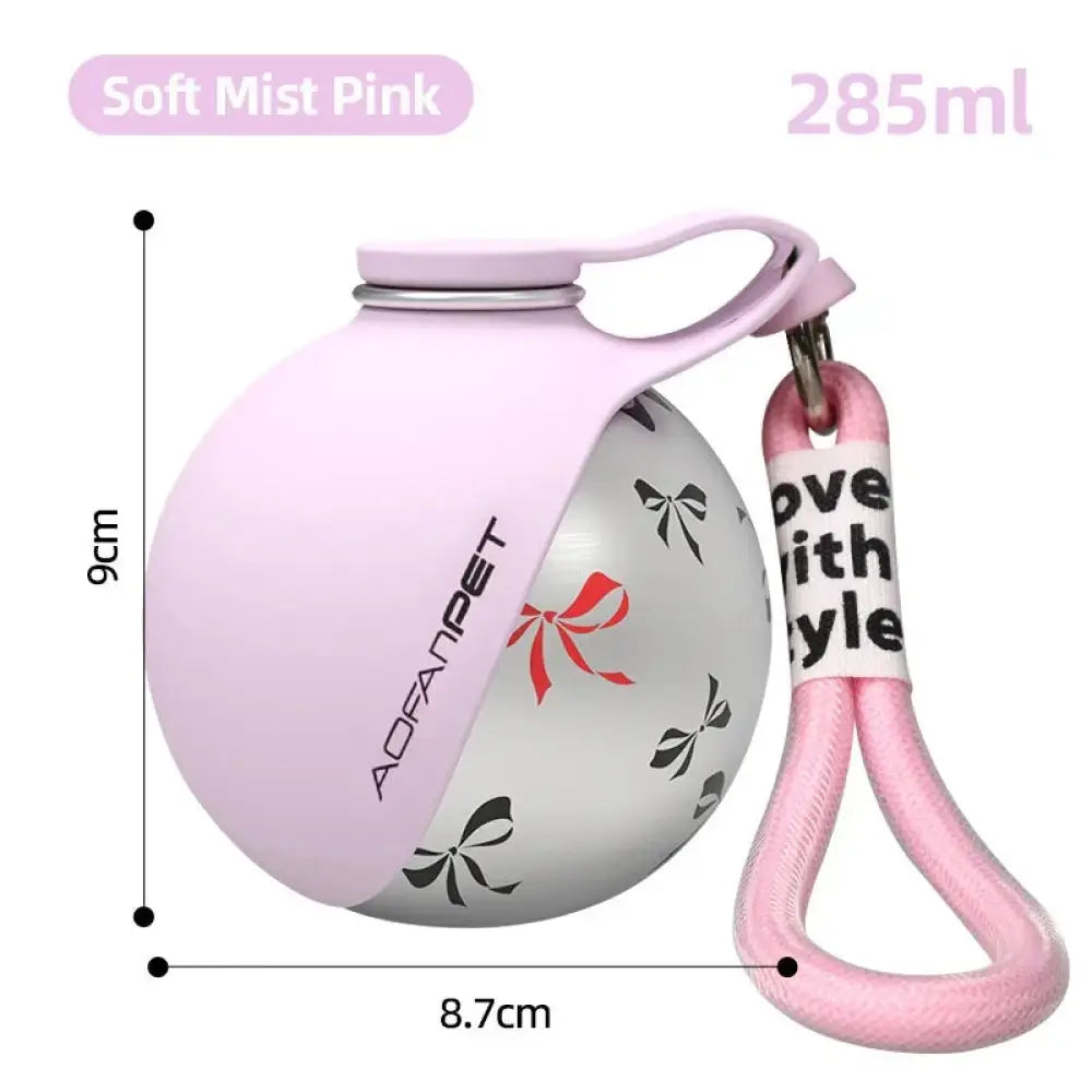 Soft mist pink stainless steel portable dog water bottle with silver rim, decorative bow, and matching silicone strap